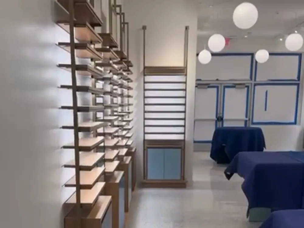 Commercial interior renovation with wooden shelving units and updated lighting.