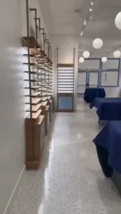 Commercial interior renovation with wooden shelving units and updated lighting.