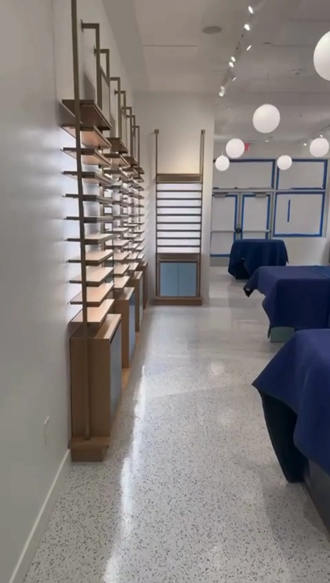 Commercial interior renovation with wooden shelving units and updated lighting.