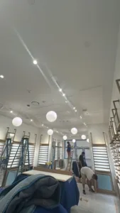 Commercial interior renovation showing workers assembling fixtures and shelving.