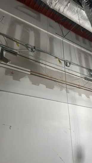 Commercial interior renovation with unfinished drywall and visible wiring.